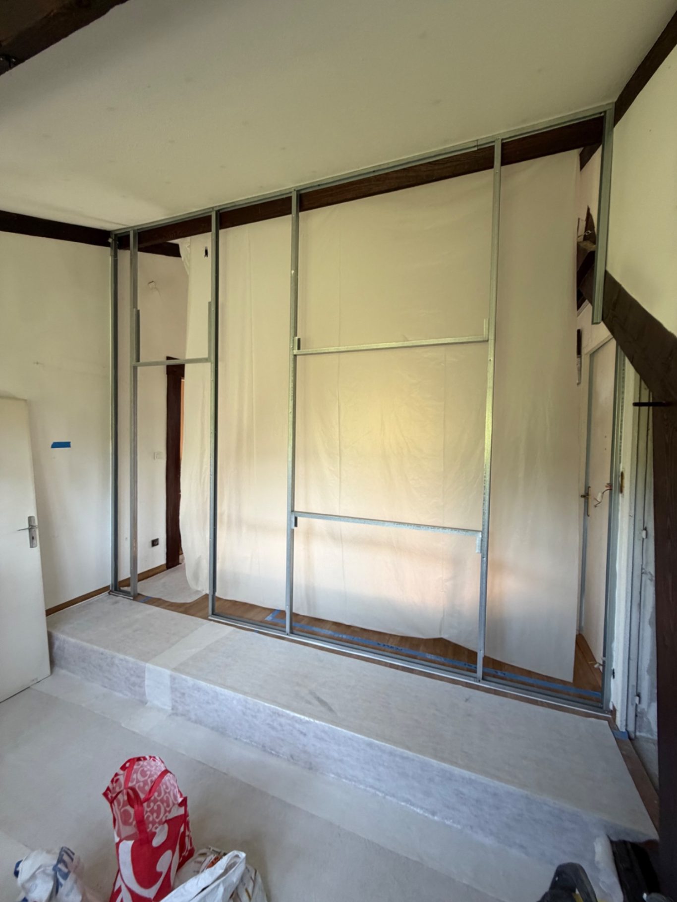 Création d'une chambre et dressing - 77 Montévrain (seine et marne) Mur en cours de construction avec une structure métallique et des panneaux blancs.