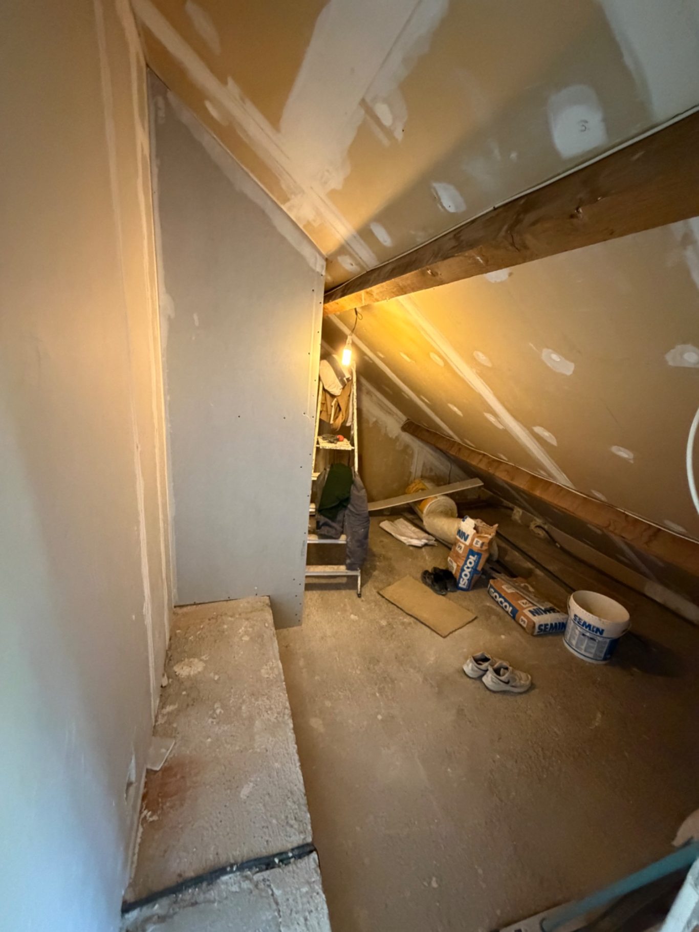 Création d'une chambre et dressing - 77 Montévrain (seine et marne) Espace de rangement sous les combles avec murs non finis et outils de bricolage.